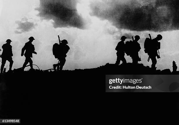 British troops in silhouette march towards trenches near Ypres at the Western Front during the First World War. In the first Battle of Ypres, October...
