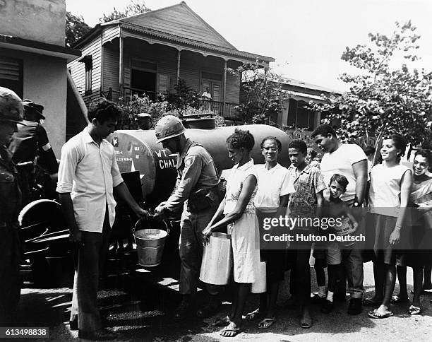 American soldiers of the 82nd Airborne Division providing residents of Santa Domingo with water, when the civil war cut off local supplies, in May...