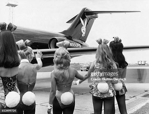 Playboy Bunnies wave as Hugh Hefner's private jet Big Bunny lands in London.