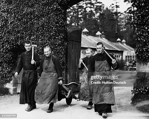 Group of monks from the Benedictine Order carry farming equipment in preparation for work on the fields.