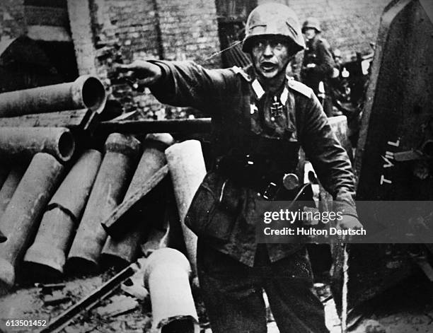 German officer shouts orders to his men from a barricade in Warsaw, Poland, during heavy fighting with Polish opponents in September 1944.