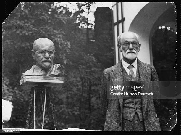 The Austrian psychiatrist and founder of the theory of psychoanalysis, Sigmund Freud stands beside a sculpture of himself.