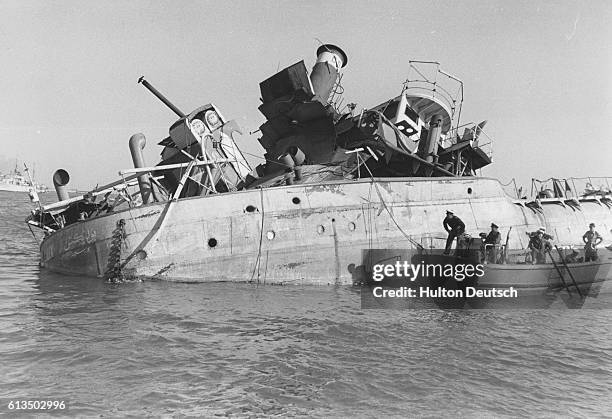 British sailors survey damaged ships in the Suez Canal to determine how to remove them at the end of the Suez Crisis.