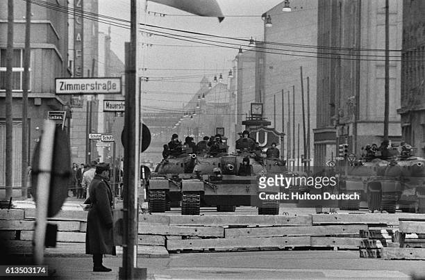 Soviet tanks and soldiers patrol a checkpoint on the Berlin Wall, Berlin, February 1961.