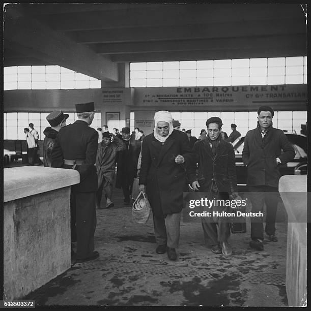 France: Marseilles. After arrival of a passenger boat from the North African coast a diversity of races and colours pass through the landing shed....