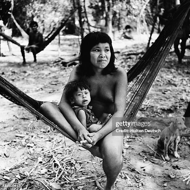 Member of the nomadic Guajibos tribe, which inhabits the area around the junction of the Sinaruco and Orinoco rivers, sits with her child in a...