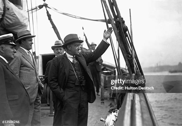 Explorer Sir Ernest Shackleton waves from aboard his ship as he sets out on a expedition.
