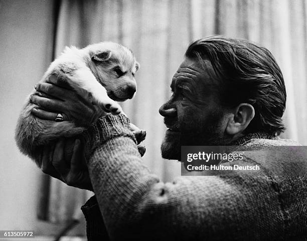 Actor John Mills holding puppy.