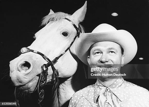 Tex Ritter, American singer and actor , stands with his horse. Tex was a singing cowboy in over 60 films including High Noon which rewarded him with...