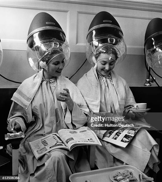 Women relax as they sit under hair dryers at the Valentino & Rita of Knightsbridge beauty salon in London, England.