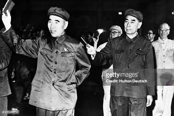 Lin Piao and the Prime Minister Chou En Lai wave their little red books containing the quotations of Chairman Mao at a 1967 celebration of his...