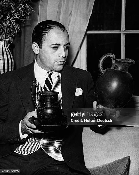 Czech film actor Herbert Lom holds some Etruscan pottery from his collection, London, 1955.