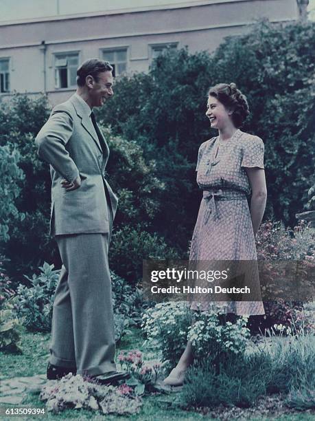 King George VI with his eldest daughter Princess Elizabeth in the garden at Windsor.