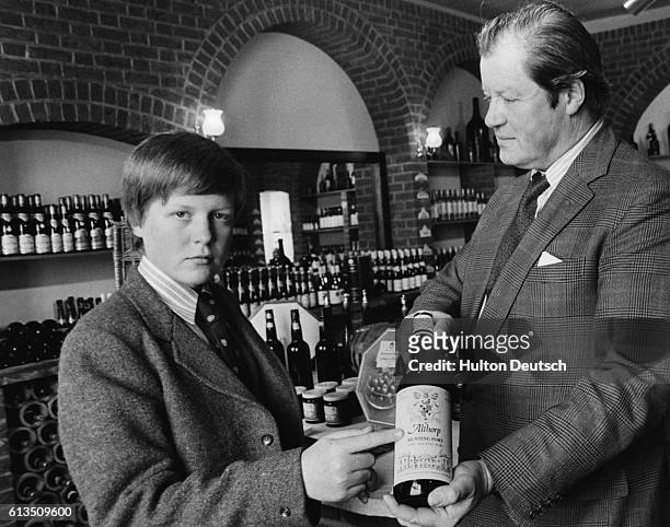 The young Viscount Althorp with his father Earl Spencer in the wine cellars of their family estate in Northamptonshire, ca. 1977.