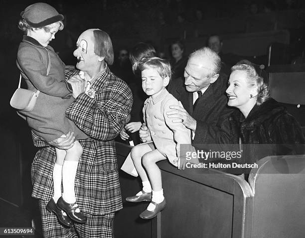 Young Jeremy Soames and his sister Emma are introduced to the world-famous entertainer Coco the Clown at an opening luncheon given by the Bertram...