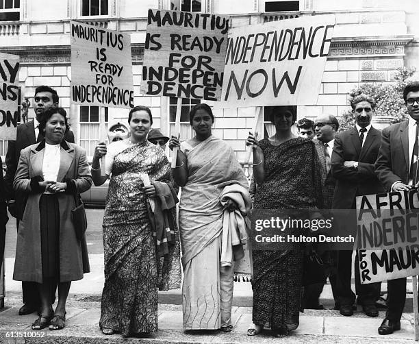 Group of protesters hold signs in support of Seewoosagur Ramgolam, the Prime Minister of Mauritius, who will speak out for Maurianian independence...