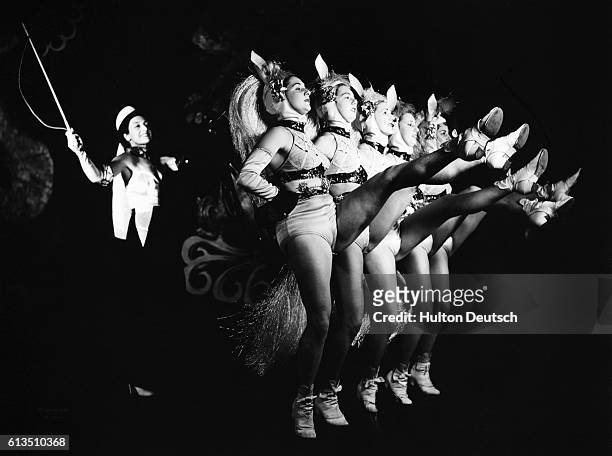 Woman stands behind the Tiller Girls during their performance at the Hippodrome.