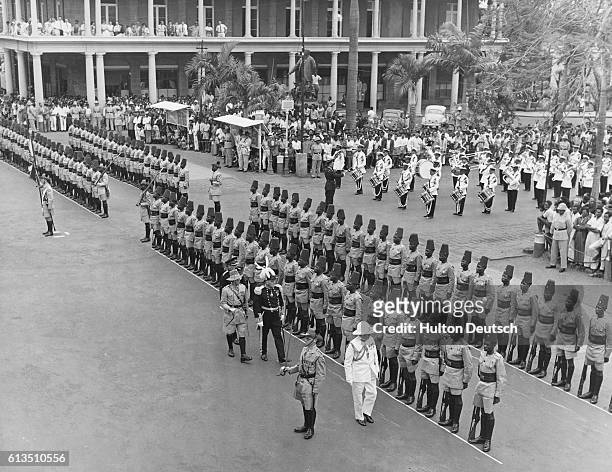 The British military garrison, the 2/6 Battalion The King's African Rifles, forms a guard of honor for inspection by Sir Robert Scott, a former...