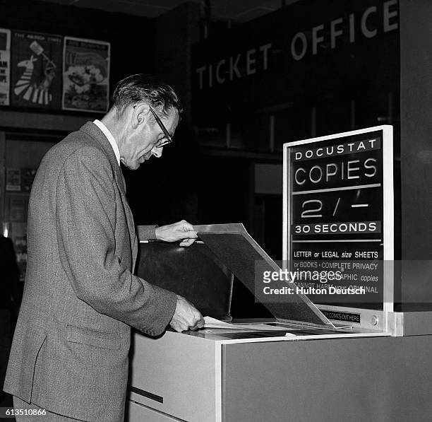 Man uses an early photocopier at London's Paddington Station, England, 1963.