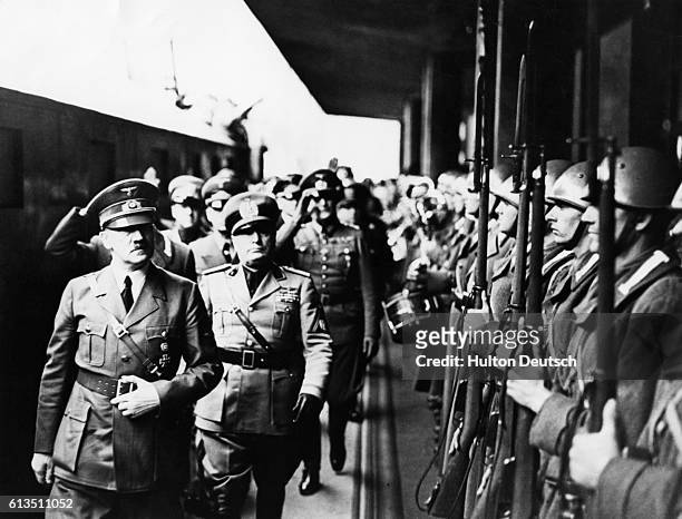 Adolf Hitler and Benito Mussolini review troops in Munich, prior to the conference that would signal the partition of Czechoslovakia.