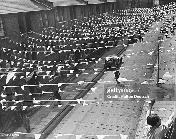 Sam Howard putting up bunting in Granham Street for the party to celebrate the 1953 Coronation of Queen Elizabeth II.