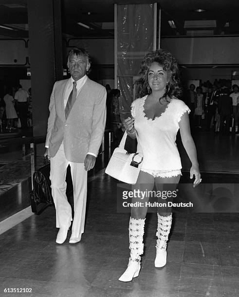 British actors Elizabeth Taylor and Richard Burton, at London Airport, in 1971. Richard Burton, born Richard Jenkins, originally came from Wales but...