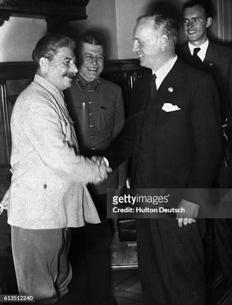 Soviet leader, Stalin, and Nazi Germany Foreign Minister, Ribbentrop, shaking hands during the Moscow meeting concerning the demarcation of Poland,...