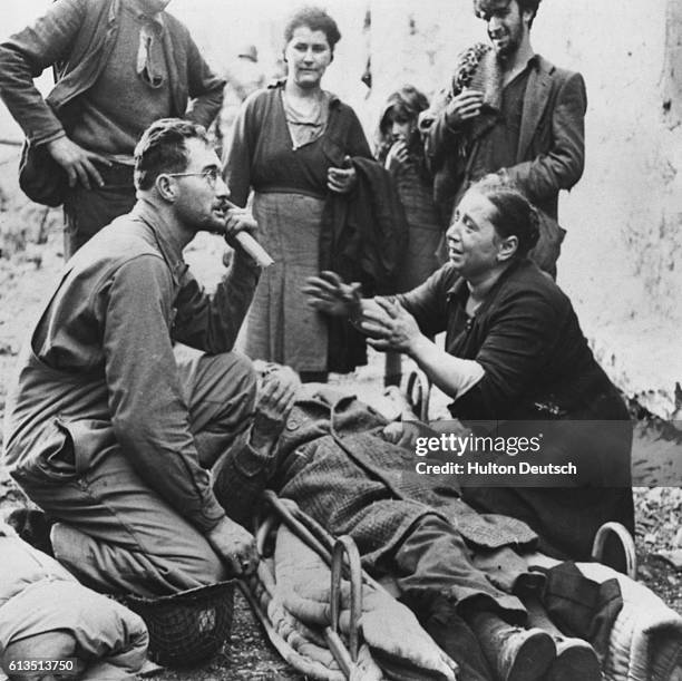 An Italian woman tells an American lieutenant about the brutal treatment her husband has received from the Nazis, Italy, 1944. | Location: Lagone,...