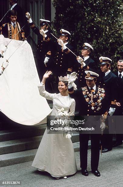 An honor guard stands at attention as King Carl Gustaf and Queen Silvia wave to onlookers after their wedding.