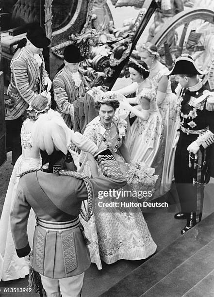 Queen Elizabeth II receives a salute from one of The Life Guards as her royal attendants help her out of her coach. Her husband, Duke Philip, is to...