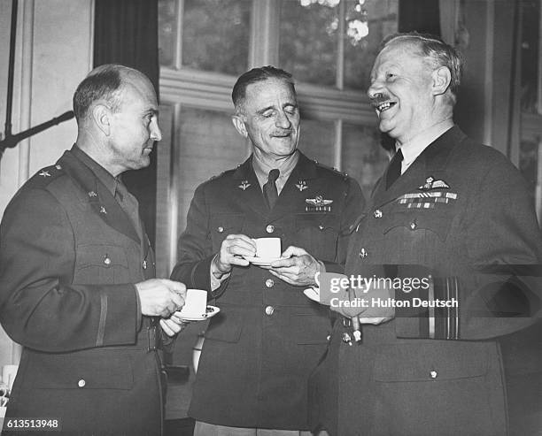 Brigadier general Ira Clarence Eaker chats, over tea, with Sir Arthur Harris and general Carl Spaatz at a US Army Air Corps station in Britain.