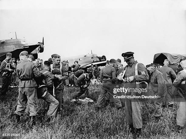 Nazi paratroopers prepare to take part in the invasion of Holland. The majority of the regiment is wearing Dutch uniforms, violating an international...