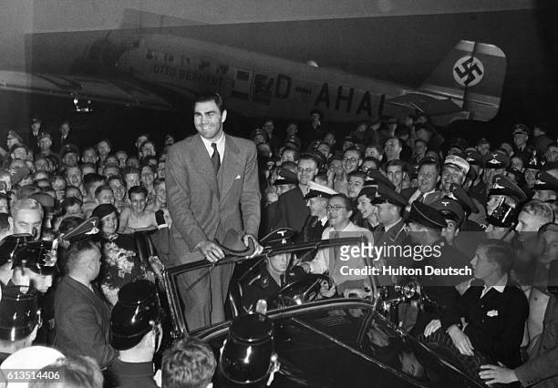 Crowd gathers to greet heavyweight boxer Max Schmeling upon his arrival at the Berlin airport.
