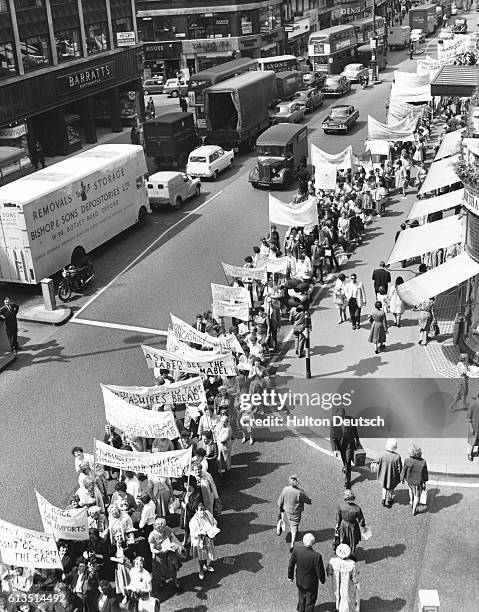 In 1962, thousands of cotton workers, from 30 towns in Lancashire, stage a protest march through London, England, to protest the rise in imported...