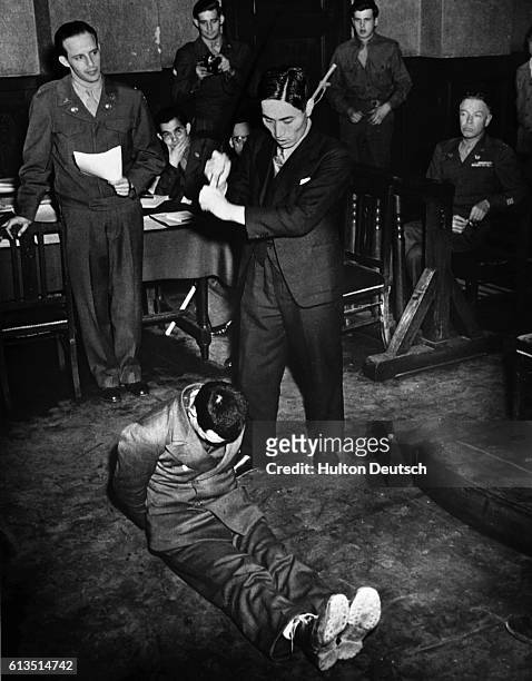 Japanese soldier re-enacts for the court how a U.S. Pilot, 2nd Lt. Darwin T. Emry, was beheaded. The demonstration was given during a military...