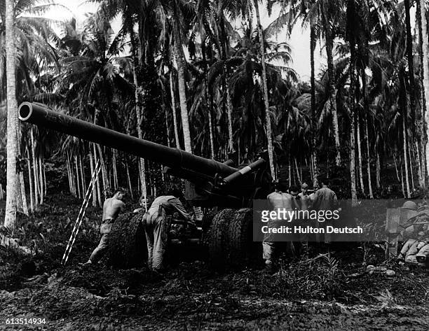 American soldiers operate 155 mm heavy artillery cannon on Rendova Island. The Japanese stronghold on near by Munda Island is the target during World...