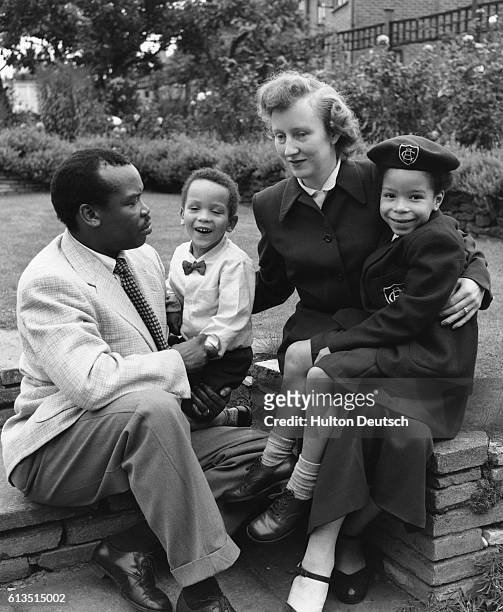 Seretse Khama, later the first President of Botswana when it gained independence, with his wife Ruth, and children in the garden of their Croydon...