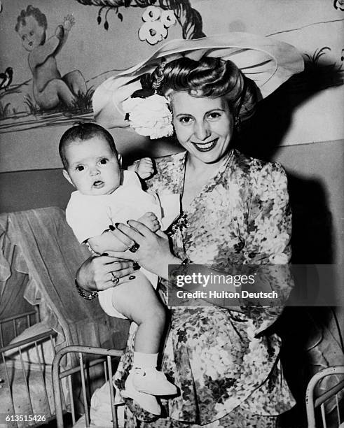 Eva Peron visits the Child Welfare Center in Rome and holds a patient.