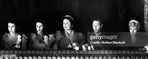 Princess Elizabeth, Princess Margaret, Queen Elizabeth, King George VI, and Queen Mary attend the reopening of the Royal Opera House at the end of...