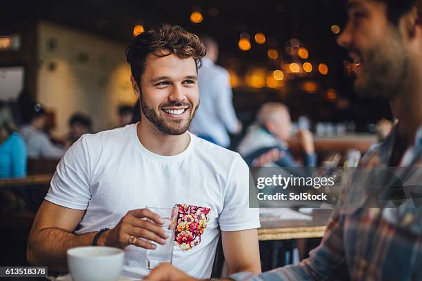 dos amigos hablando en un café - amigos hombres en restaurant fotografías e imágenes de stock