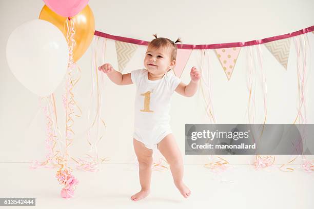 baby girl's first birthday and first steps - baby standing stock pictures, royalty-free photos & images