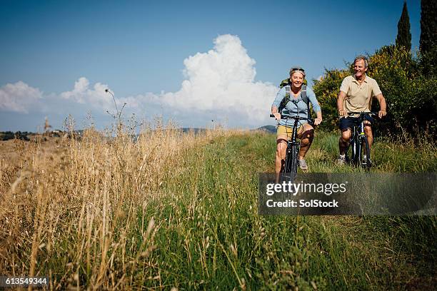 seniors on mountain bikes in the countryside - couple cycling stock pictures, royalty-free photos & images