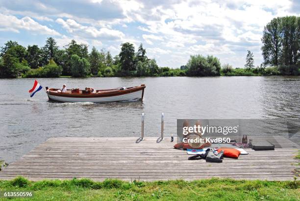 boating and sunbathing along the wijde aa - chalupa imagens e fotografias de stock