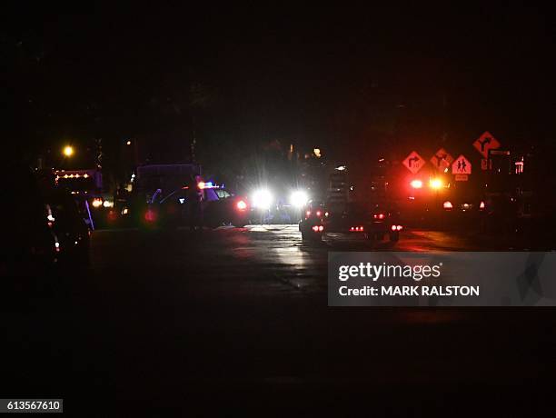 Police officers gather at a crime scene on the 2700 block of Cypress Avenue where two police officers were killed and another injured after...