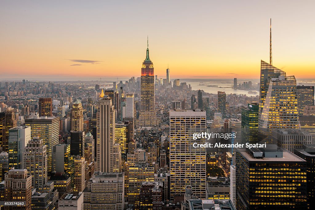 New York City skyline with illuminated skyscrapers seen from above during sunrise, New York State, USA