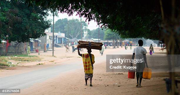 africa, southern africa, mozambique, mueda, view of muslim man carrying stack of firewood on his head - mozambique stock pictures, royalty-free photos & images