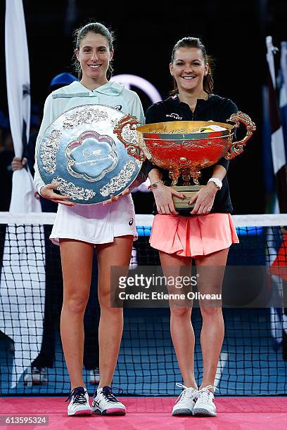 Johanna Konta of Great Britain holds the runner up trophy next to Agnieszka Radwanska of Poland who holds the winners trophy after the Women's...