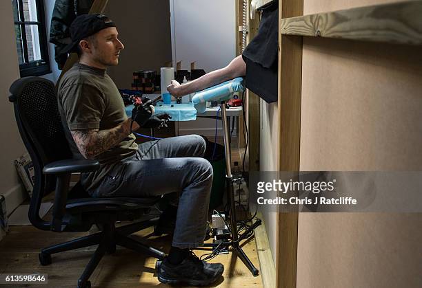 Cameron Ward has his first ever tattoo through a hole in the wall at celebrity tattoo artist Scott Campbell's event 'Whole Glory' on October 9, 2016...