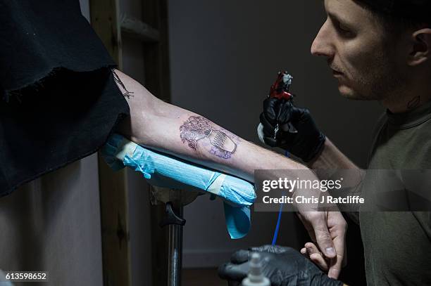 Cameron Ward has his first ever tattoo through a hole in the wall at celebrity tattoo artist Scott Campbell's event 'Whole Glory' on October 9, 2016...