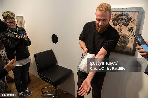 Cameron Ward unveils his first ever tattoo done through a hole in the wall at celebrity tattoo artist Scott Campbell's event 'Whole Glory' on October...